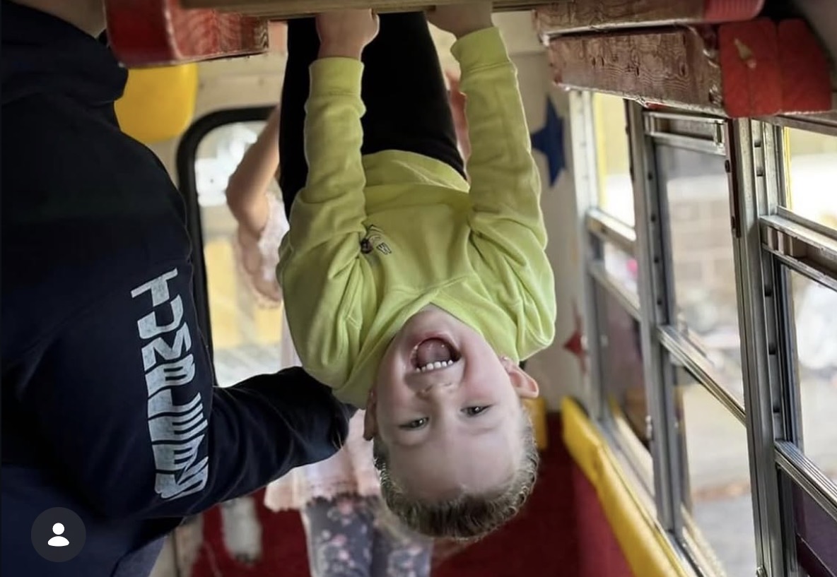 A smiling child enjoying an activity inside the Tumblebus