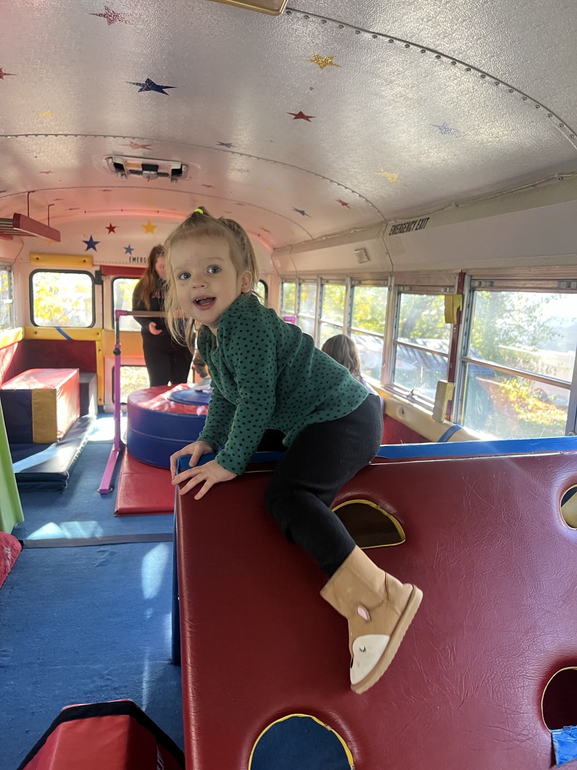 A child enjoying colorful equipment inside the Tumblebus