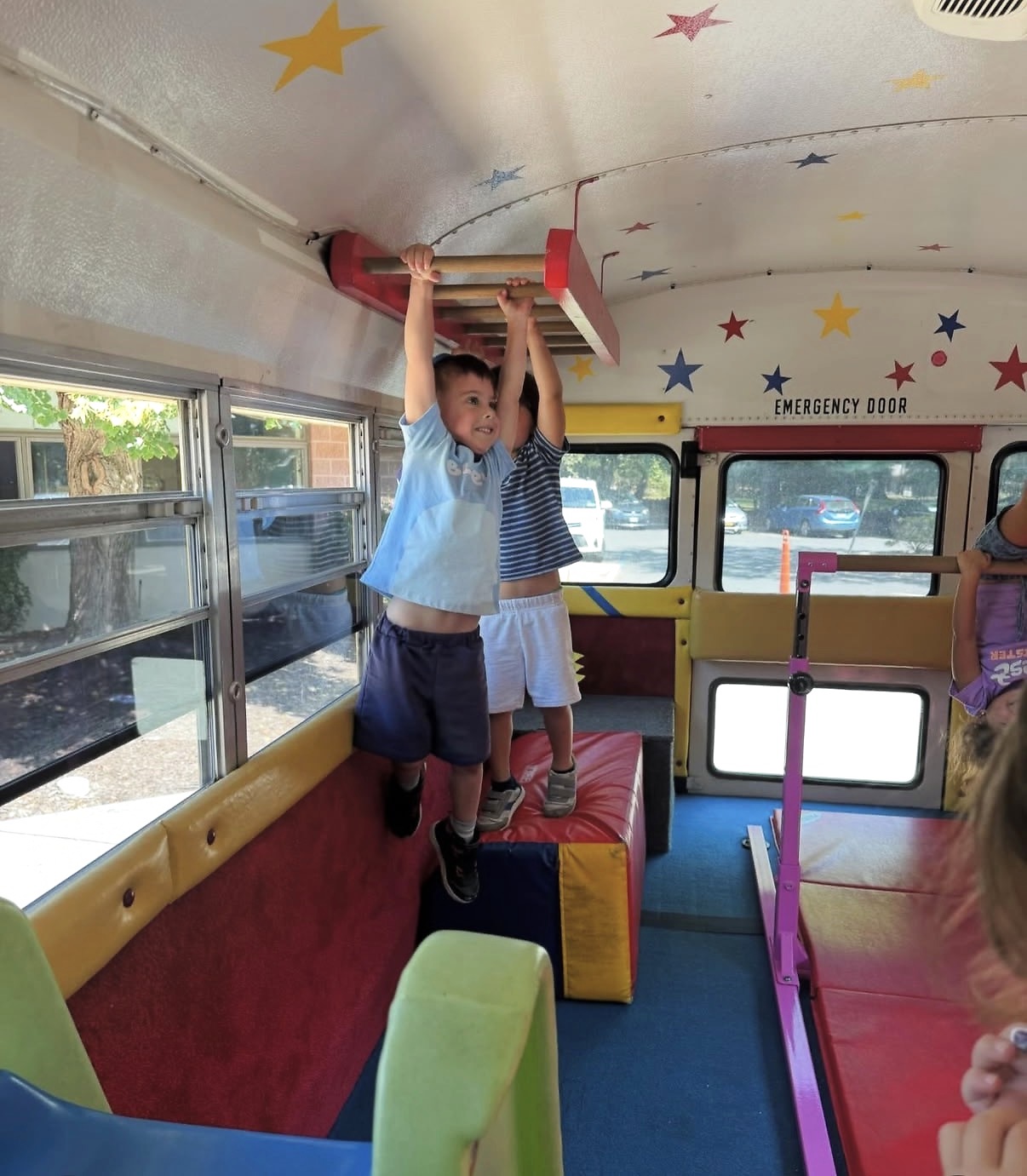 Children playing on the monkey bars inside the Tumblebus